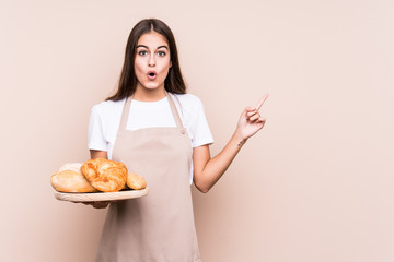 Young caucasian baker woman isolated pointing to the side
