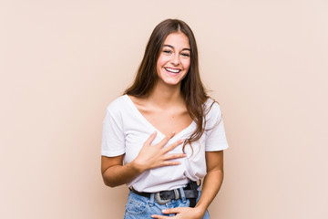 Young caucasian woman posing isolated laughs happily and has fun keeping hands on stomach.