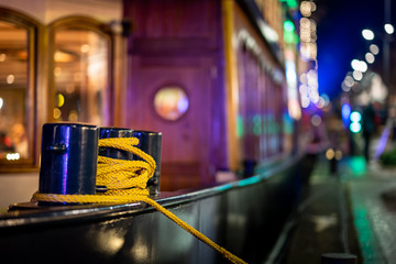 Bollard of a ship in the harbor with the bokeh of patches and colored lighting