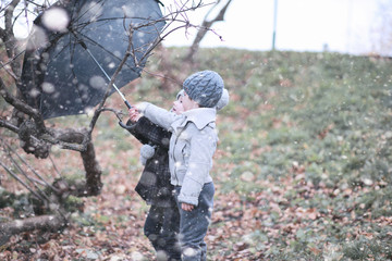 Naklejka premium Kids walk in the park first snow