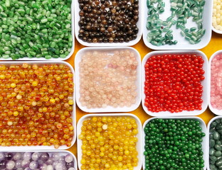 Palette of colors beads in the plastic box close up