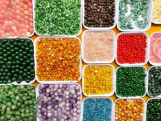 Palette of colors beads in the plastic box close up
