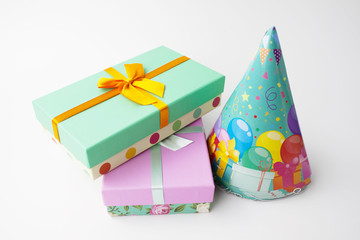 Pair gift paper cardboard boxes, bow, stack holiday caps. White background. Birthday party concept.