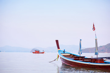 Fototapeta premium Travel by Thailand. Landscape with traditional longtail fishing boat on the sea beach.