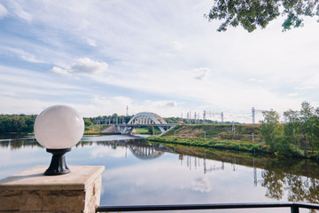 Electric locomotive crossing through the Moskva river at suburban area.