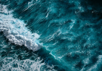 Fototapeta na wymiar Aerial view to seething waves with foam. Blue water background. Dramatic colors photo.