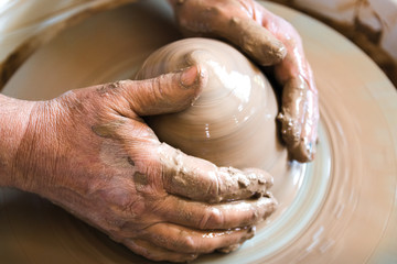 Portrait of craftsman working with clay in pottery workshop. Small business concept.