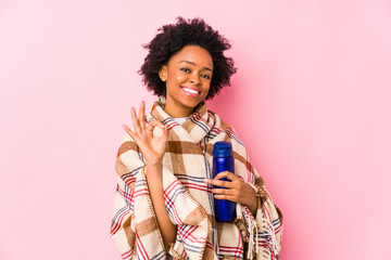 Middle age african american woman in a camping isolatedcheerful and confident showing ok gesture.