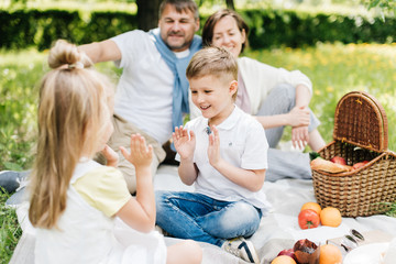 Siblings playing at the picnic together smiling.