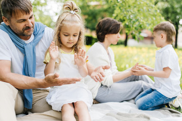 Fototapeta premium Parents playing with their kids at the picnic.