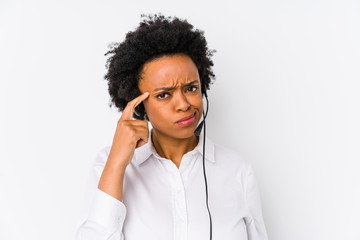 Young african american telemarketer woman isolated pointing temple with finger, thinking, focused on a task.