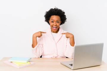 Middle aged african american woman working at home isolated surprised pointing with finger, smiling broadly.