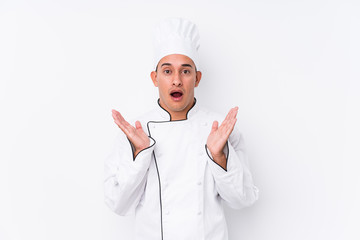 Young latin chef man isolated surprised and shocked.