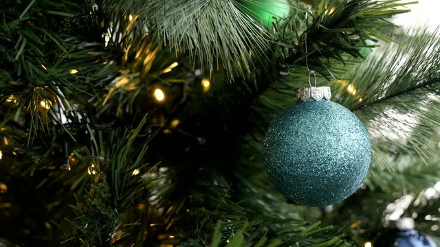 Blue Christmas ball on tree branches with fairy lights 4K footage