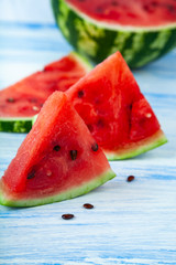 Pieces of watermelon on a blue wooden table.