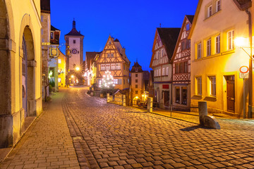 Fototapeta na wymiar Decorated and illuminated Christmas street with gate and tower Plonlein in medieval Old Town of Rothenburg ob der Tauber, Bavaria, southern Germany