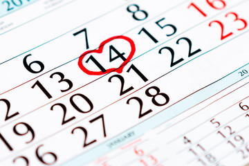 Red hearts on calendar with marked date of Valentines Day, closeup Calendar page with the red hearts on February 14