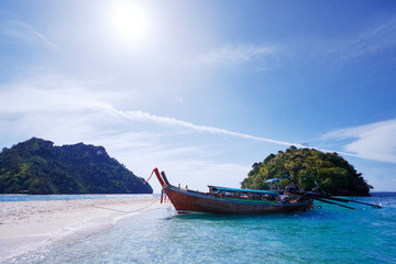 Fototapeta na wymiar Beautiful landscape with traditional longtail boats, rocks, cliffs, tropical white sand beach. Traveling by Thailand.