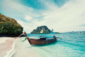 Beautiful landscape with traditional longtail boats, rocks, cliffs, tropical white sand beach. Traveling by Thailand.
