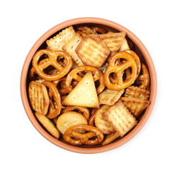 Salty cracker and pretzel snacks, party mix in clay bowl isolated on white background, top view