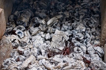 Extinct coals in a bonfire between the stones.