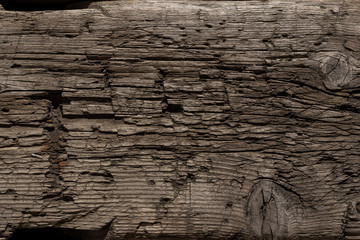 A very old shabby and battered wooden background with deep cuts from a knife and traces of blows...