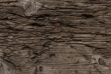 A very old shabby and battered wooden background with deep cuts from a knife and traces of blows...
