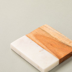 Square shaped-wooden cutting board with marble texture on a grey background