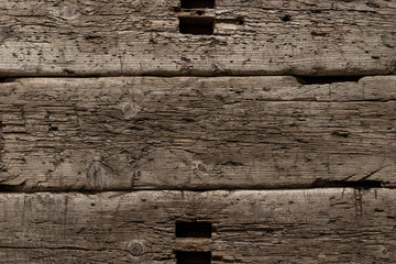 A very old shabby and battered wooden background with deep cuts from a knife and traces of blows...
