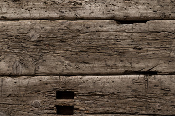 A very old shabby and battered wooden background with deep cuts from a knife and traces of blows...