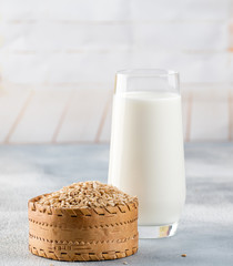 Glass of vegan oat milk and Oat on a table, space for text.