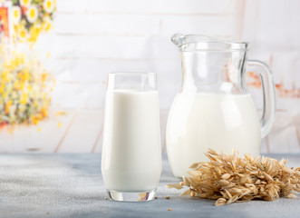 Glass of vegan oat milk and Oat on a table, space for text.