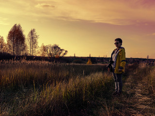 Woman photographer chooses a place to shoot a beautiful landscape. Autumn, sunset.