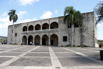 Fototapeta na wymiar Edificio Colonial en Santo Domingo, con palmeras a ambos lados