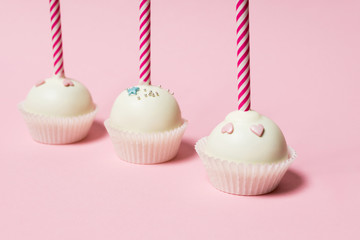 Colorful cake pops on a pink background
