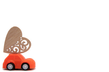 Miniature pink and yellow cars carrying heart cushions. Minimal concept.