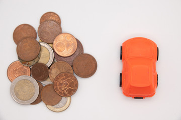 red car over a lot of golden coins isolated on white