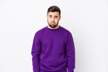 Obraz premium Young caucasian man against a white background isolated blows cheeks, has tired expression. Facial expression concept.