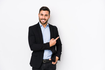 Young caucasian business man against a white background isolated smiling and pointing aside, showing something at blank space.