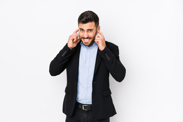 Young caucasian business man against a white background isolated covering ears with hands.