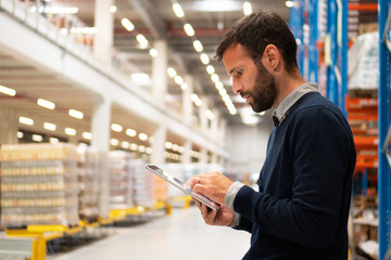 Manager holding digital tablet in warehouse