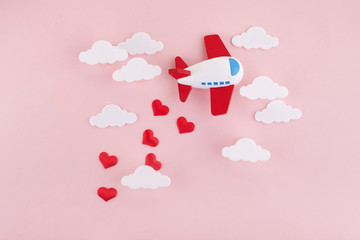 Happy Valentines day. Children's plane on a pink background with red heart and white clouds