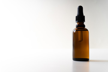 A small bottle with a dropper full of CBD oil or any other oil on white background