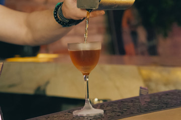 Bartender pouring cocktail at bar counter