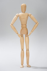 Wooden doll with shadow on grey background