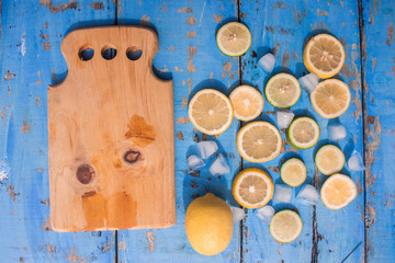 Sliced Lemons and Limes with ice cube. Over blue wood table background with copy space ,spring time concept
