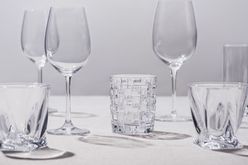 Empty glasses on white tablecloth isolated on grey