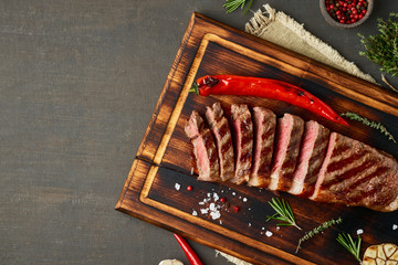 Keto ketogenic diet medium beef steak, grilled striploin on cutting board. Paleo food recipe with meat