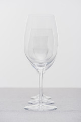 Row of clear wine glasses on cloth isolated on grey