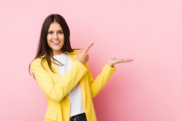 Young business woman excited holding a copy space on palm.